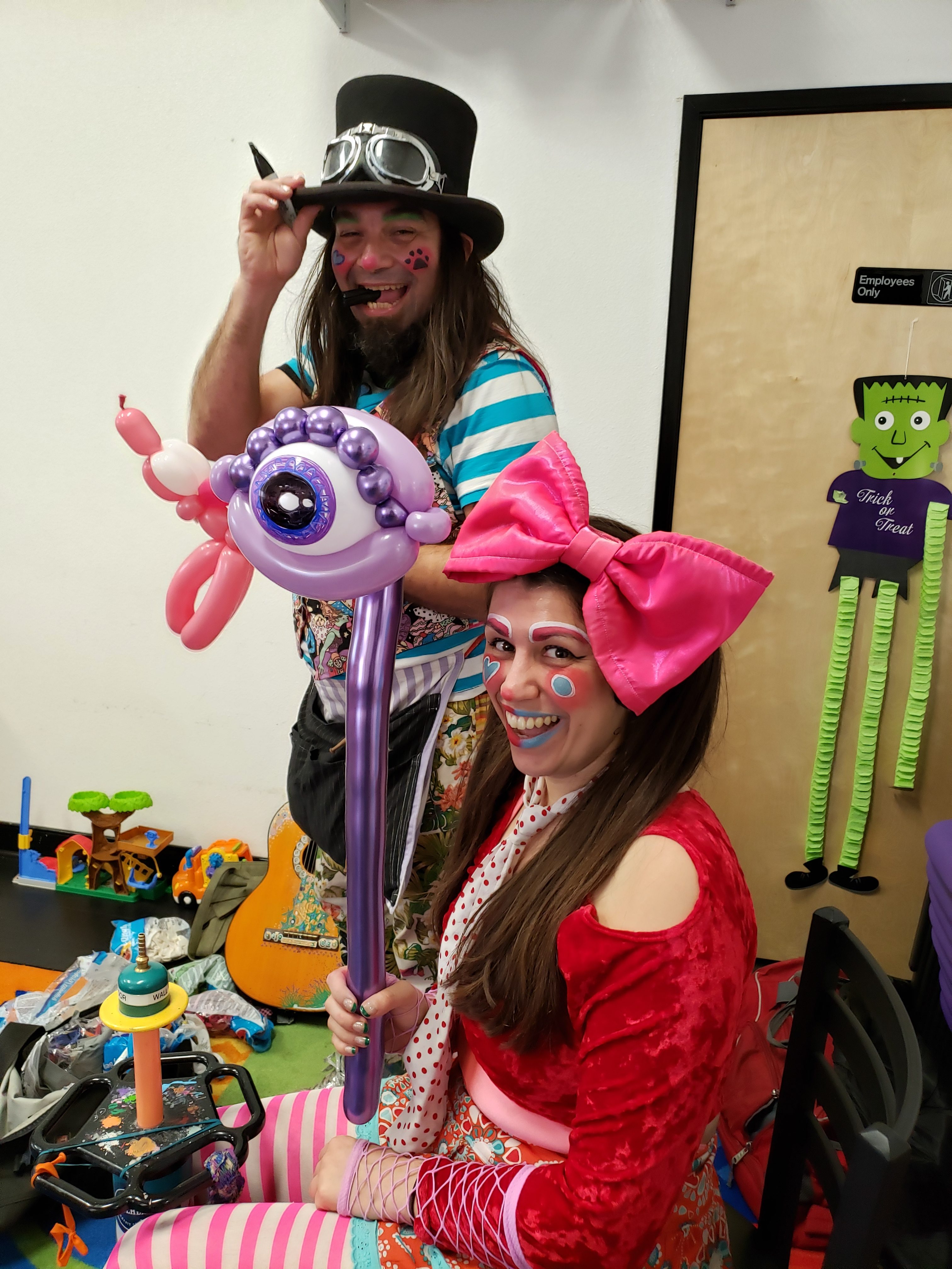 Olive and Dingo at a Birthday Party at Two Sisters Play Cafe. Olive is holding a balloon animal eyeball.