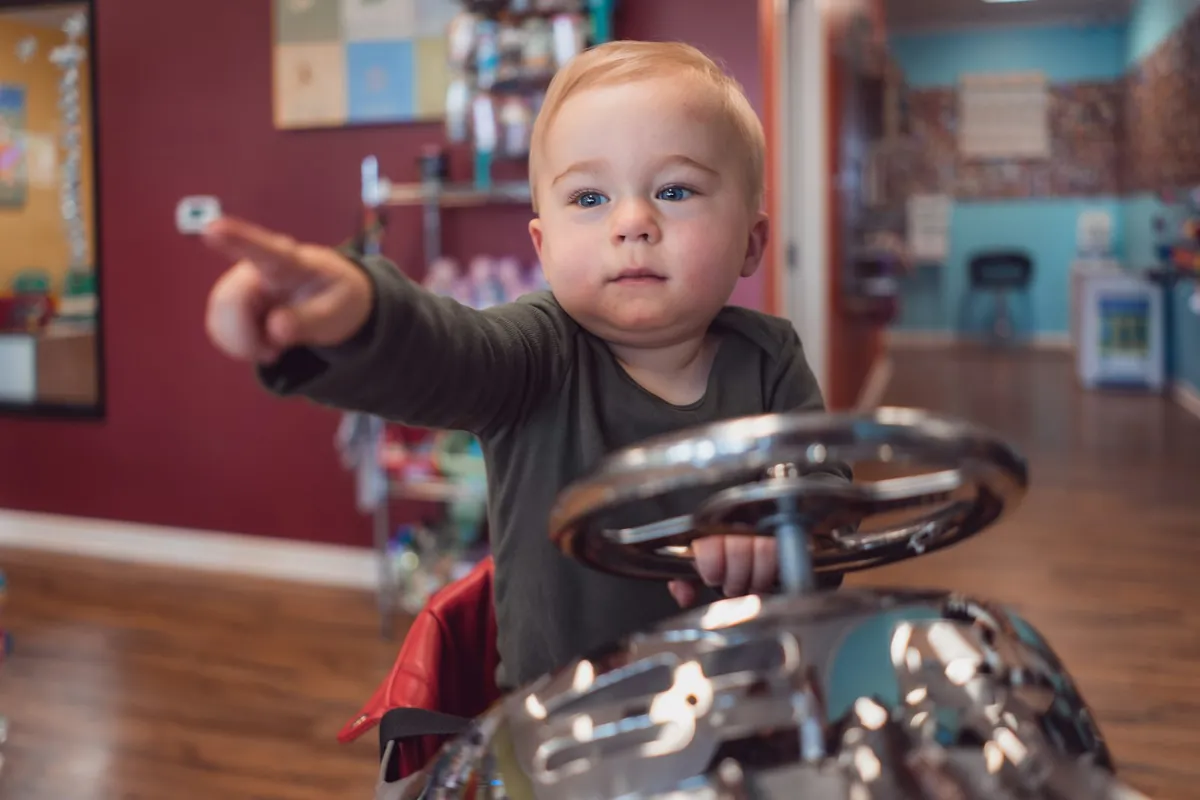 A baby holding a small tambourine at a class