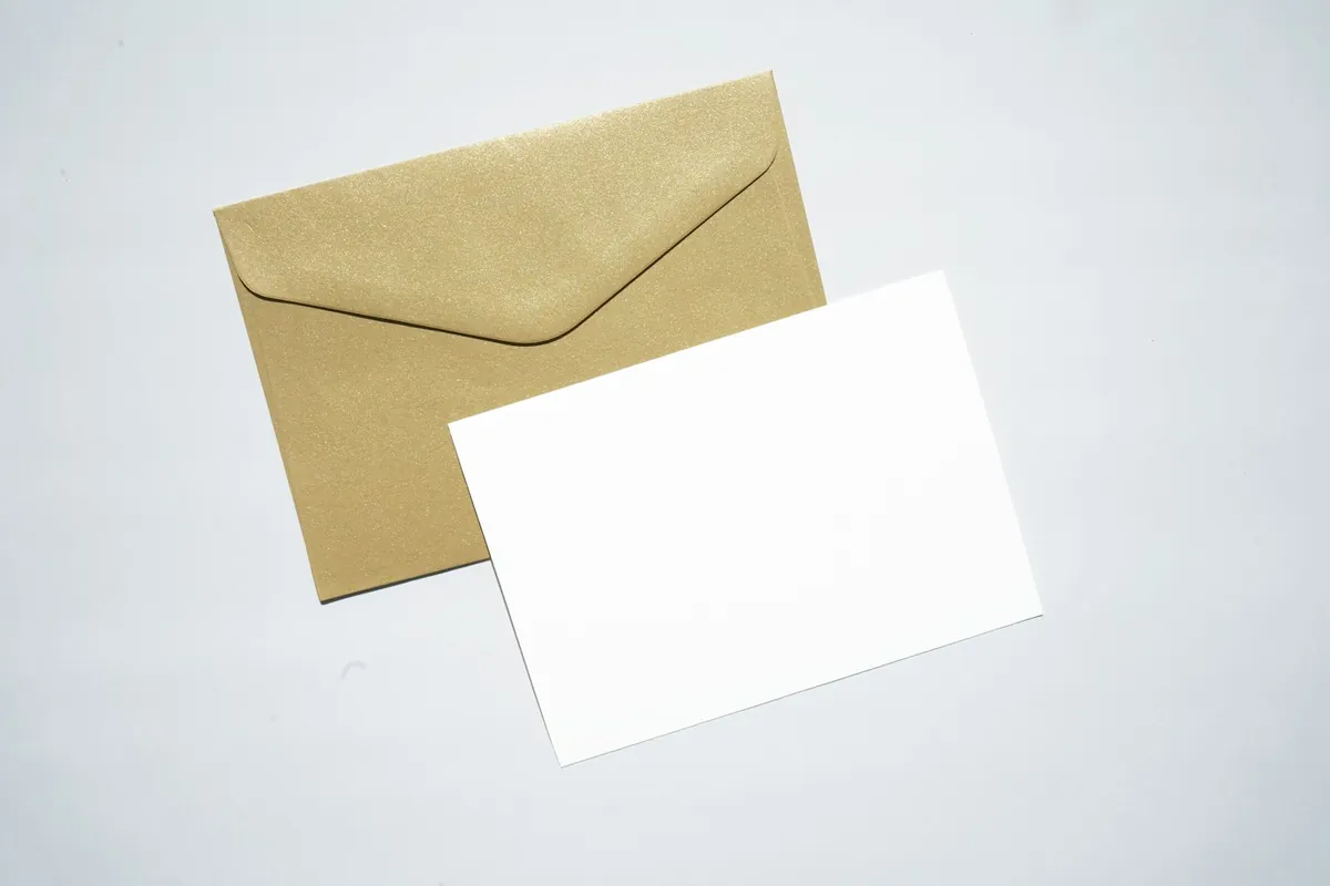 A blank white card resting on a kraft paper envelope