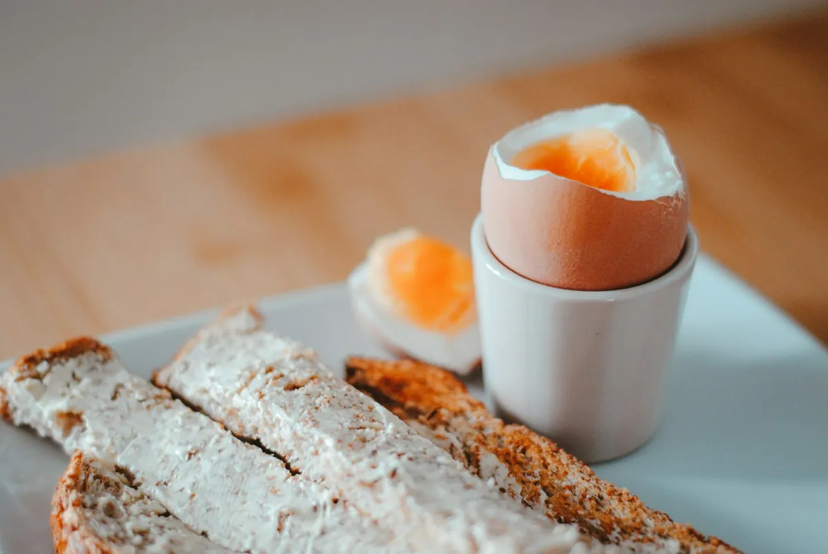 A boiled egg served with slices of bread