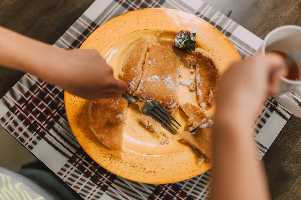 A bowl of food photographed from above on a patterned tablecloth