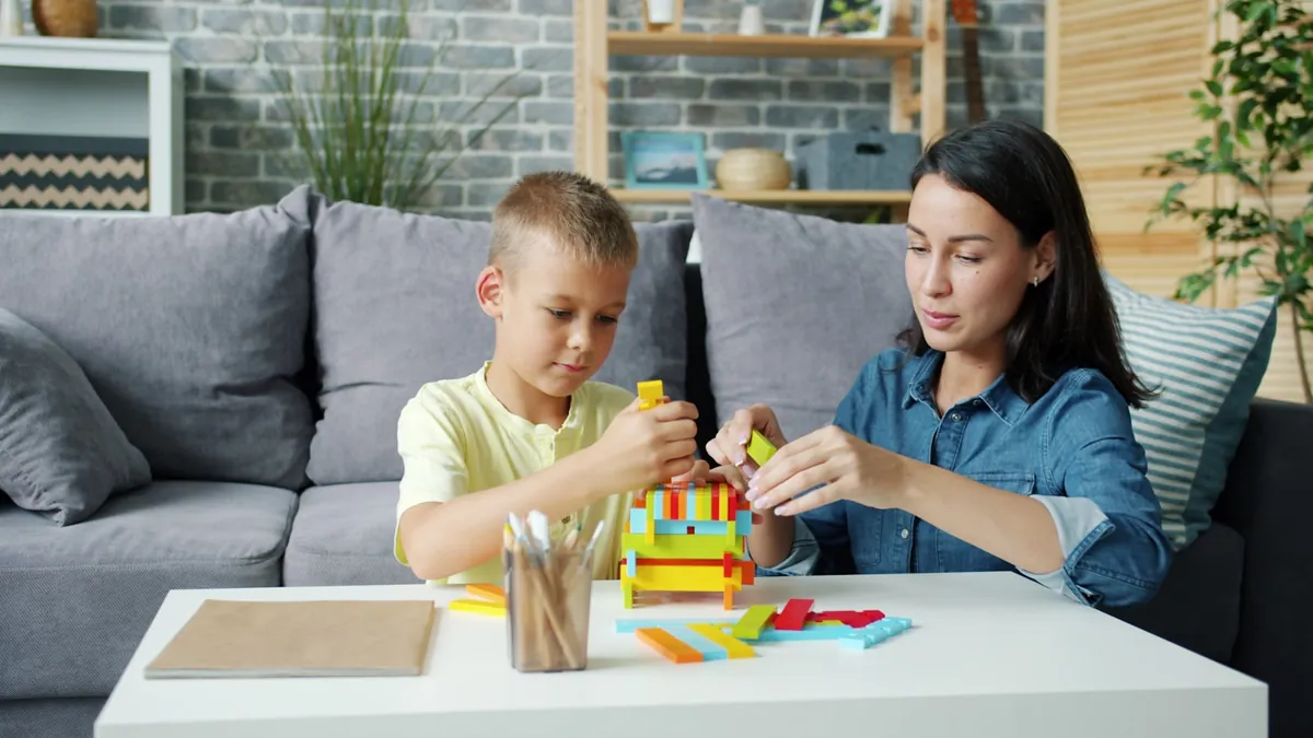 A child and an adult playing with toys together at a table