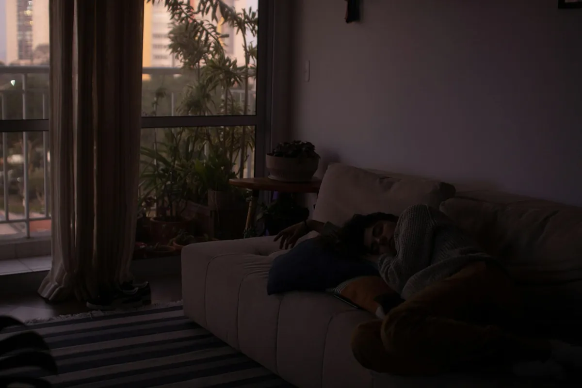 A child asleep on a sofa in a quiet, dim room