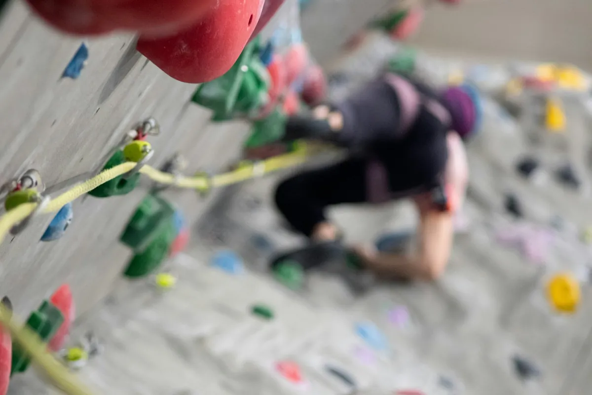 A child climbing a low indoor climbing wall