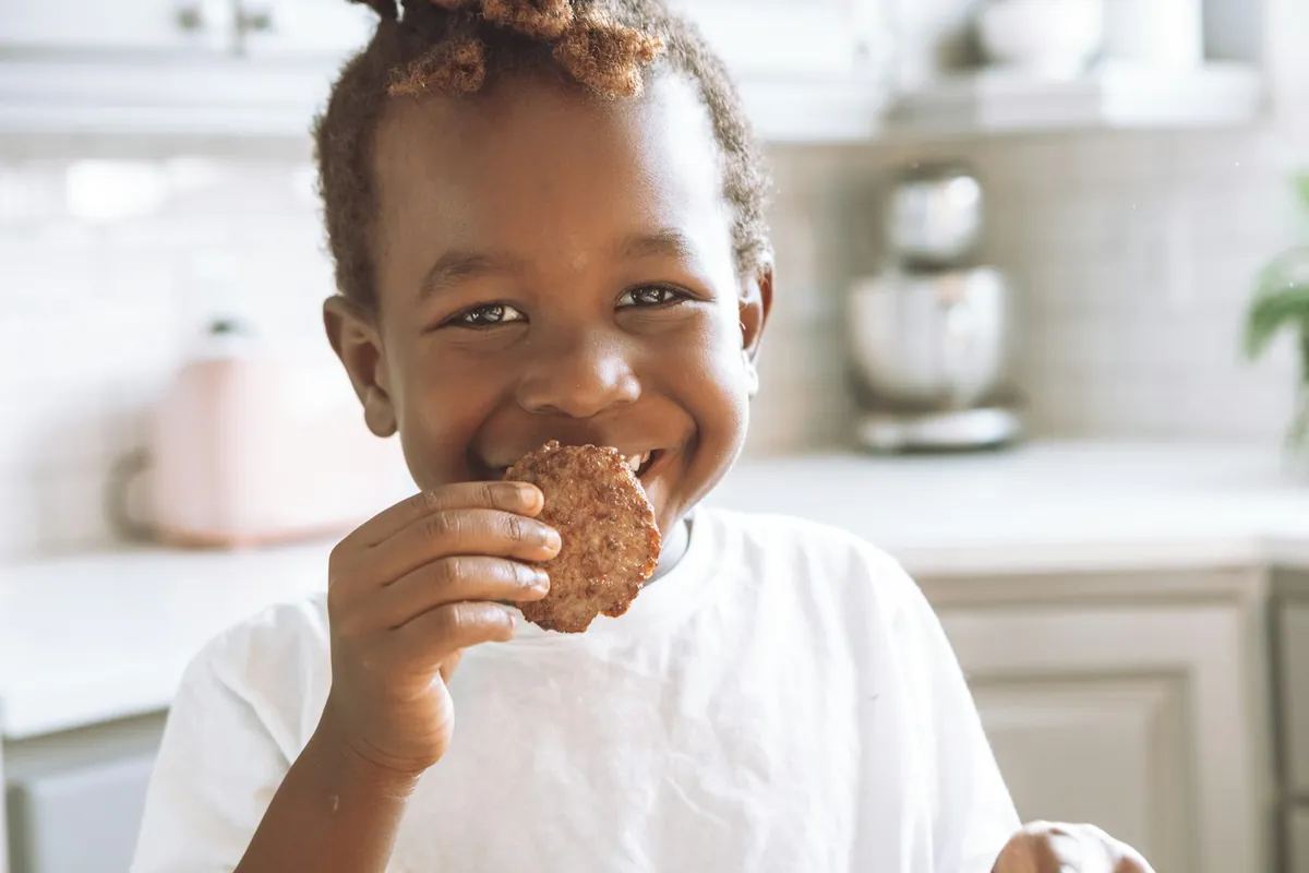 A young child happily eating a snack