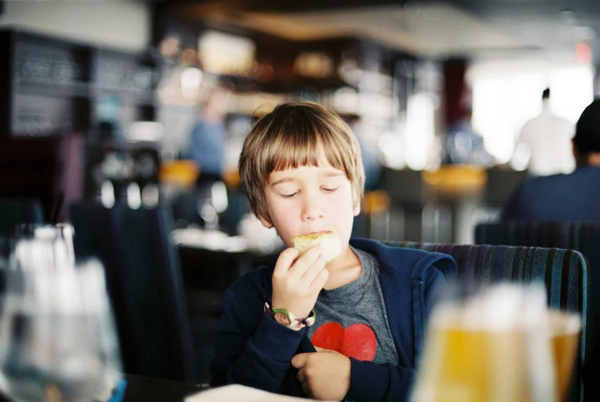 A young child eating at a table in a restaurant