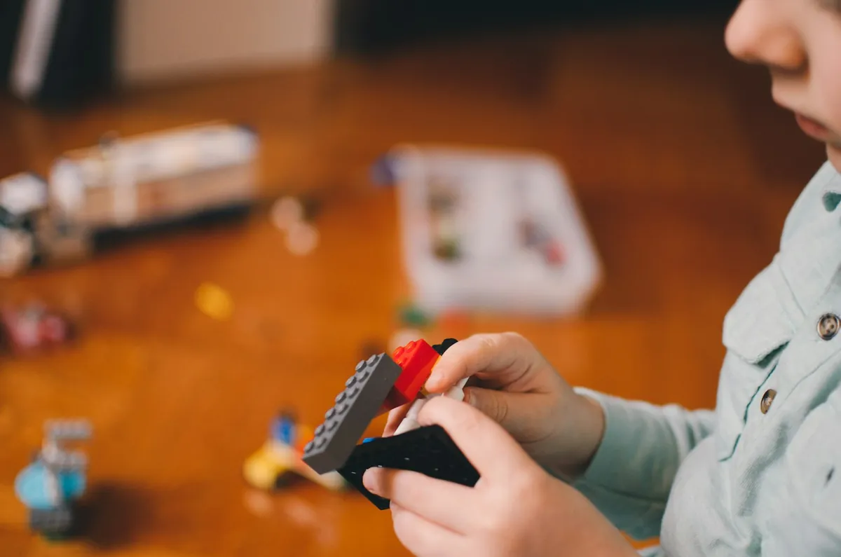 A child playing with small toy vehicles indoors