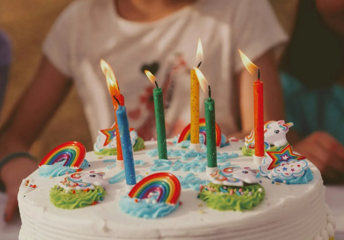 A children birthday cake with five lit candles