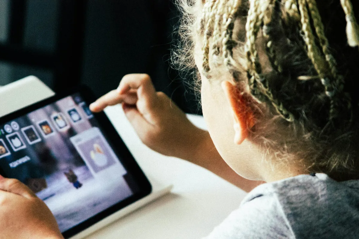 A hand scrolling through images on a tablet screen