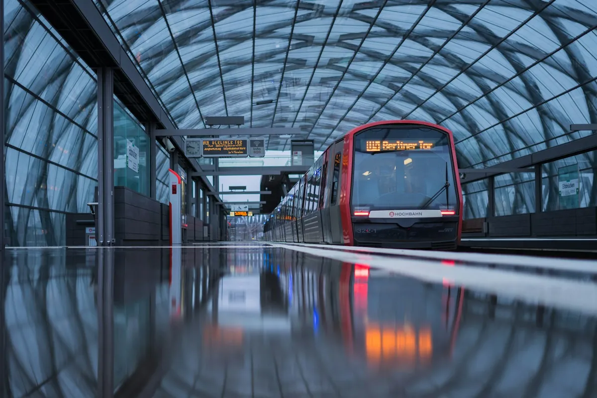 A modern station concourse with a train alongside