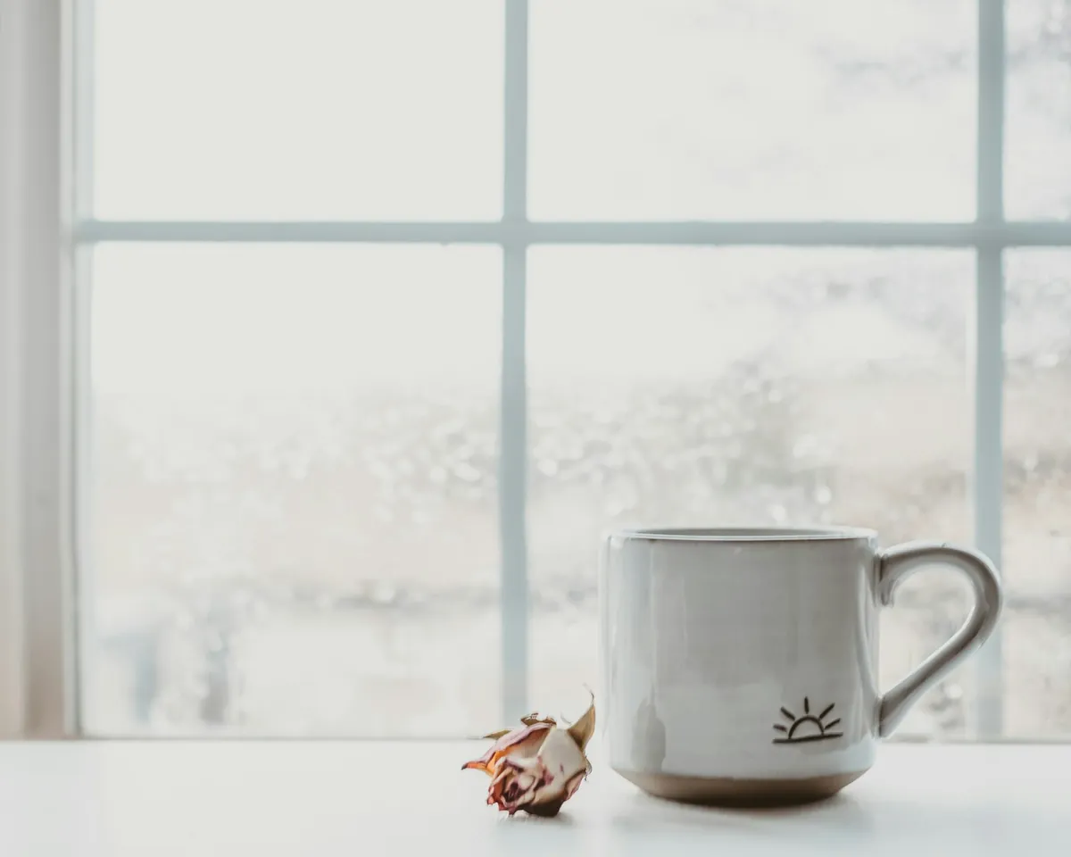 A mug resting beside a frosted window
