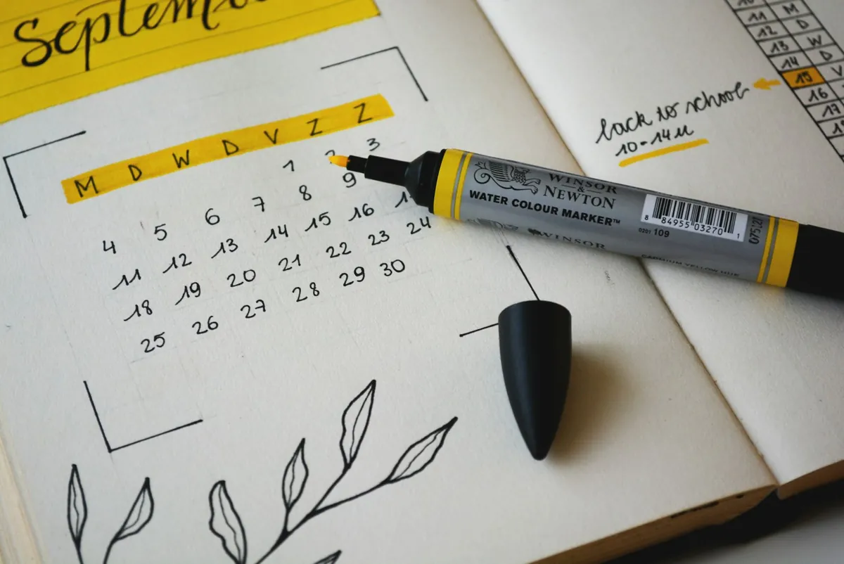 A notebook and calendar page with a marker pen