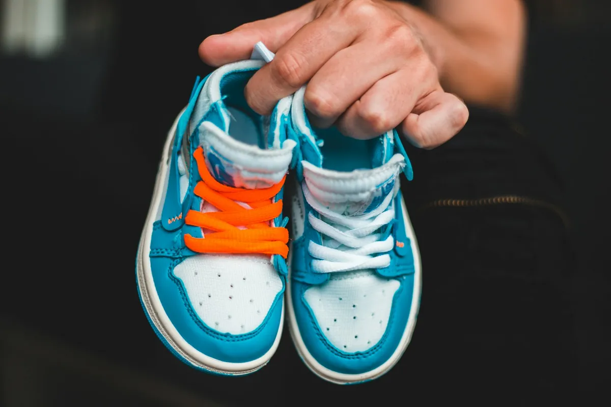 A pair of small trainers held up