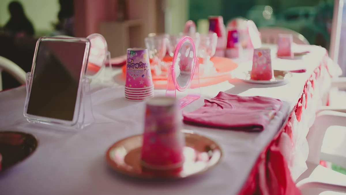 A children party table laid with pink plates and cups