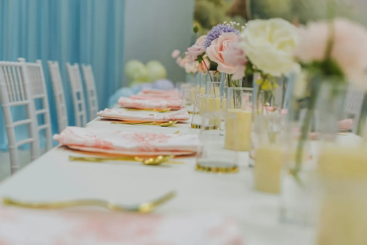 A long party table laid with flowers and glasses