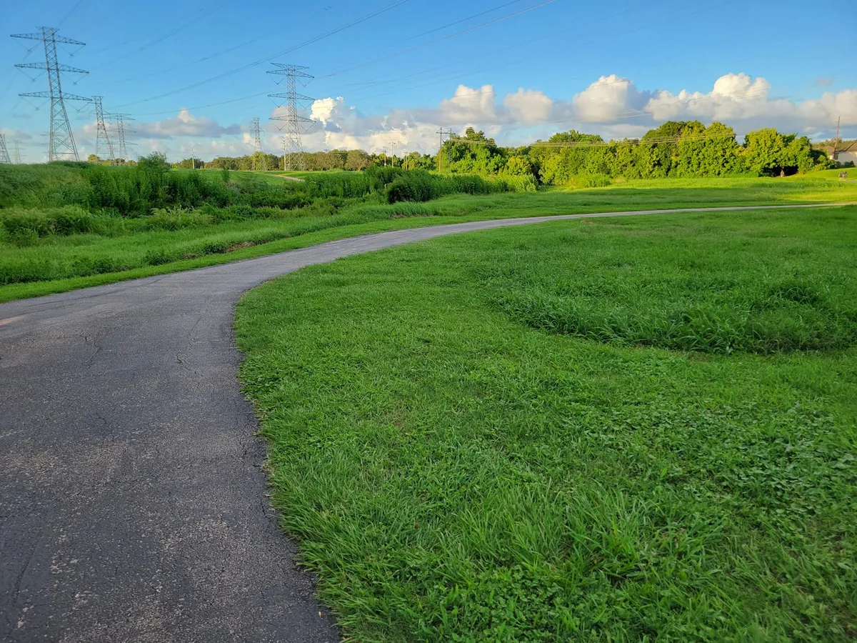 A paved path curving across open grassland