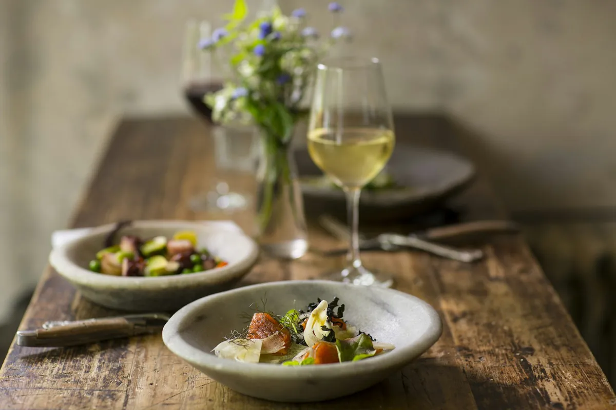 A plated dish and a glass on a wooden table