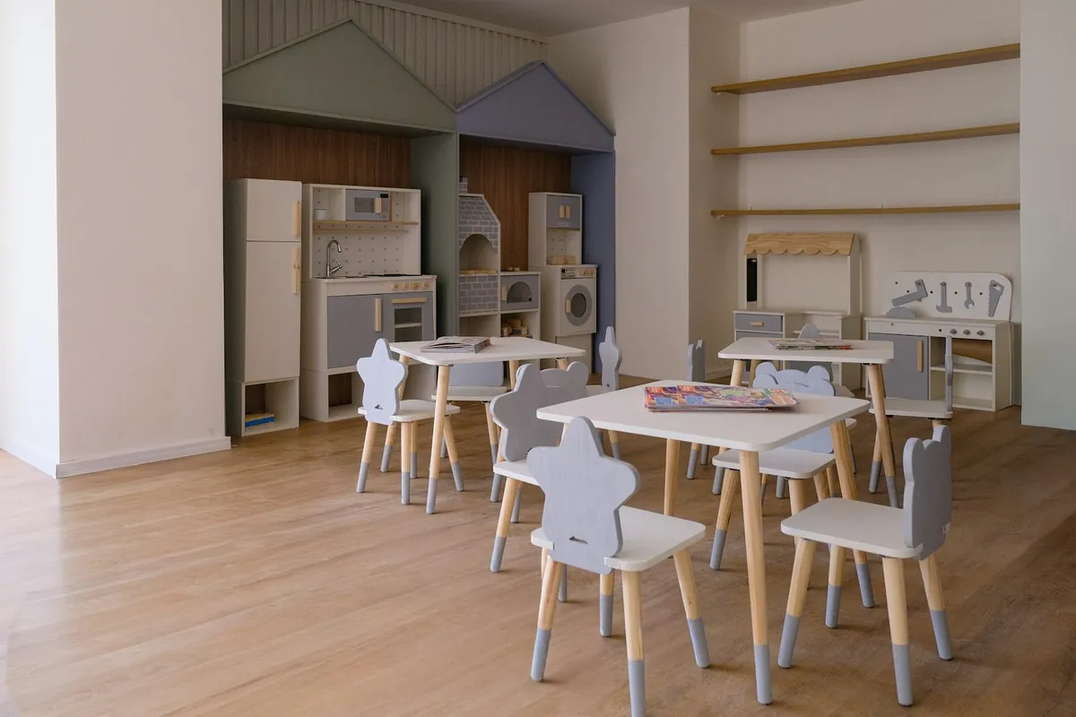 A play room with small wooden chairs and play houses