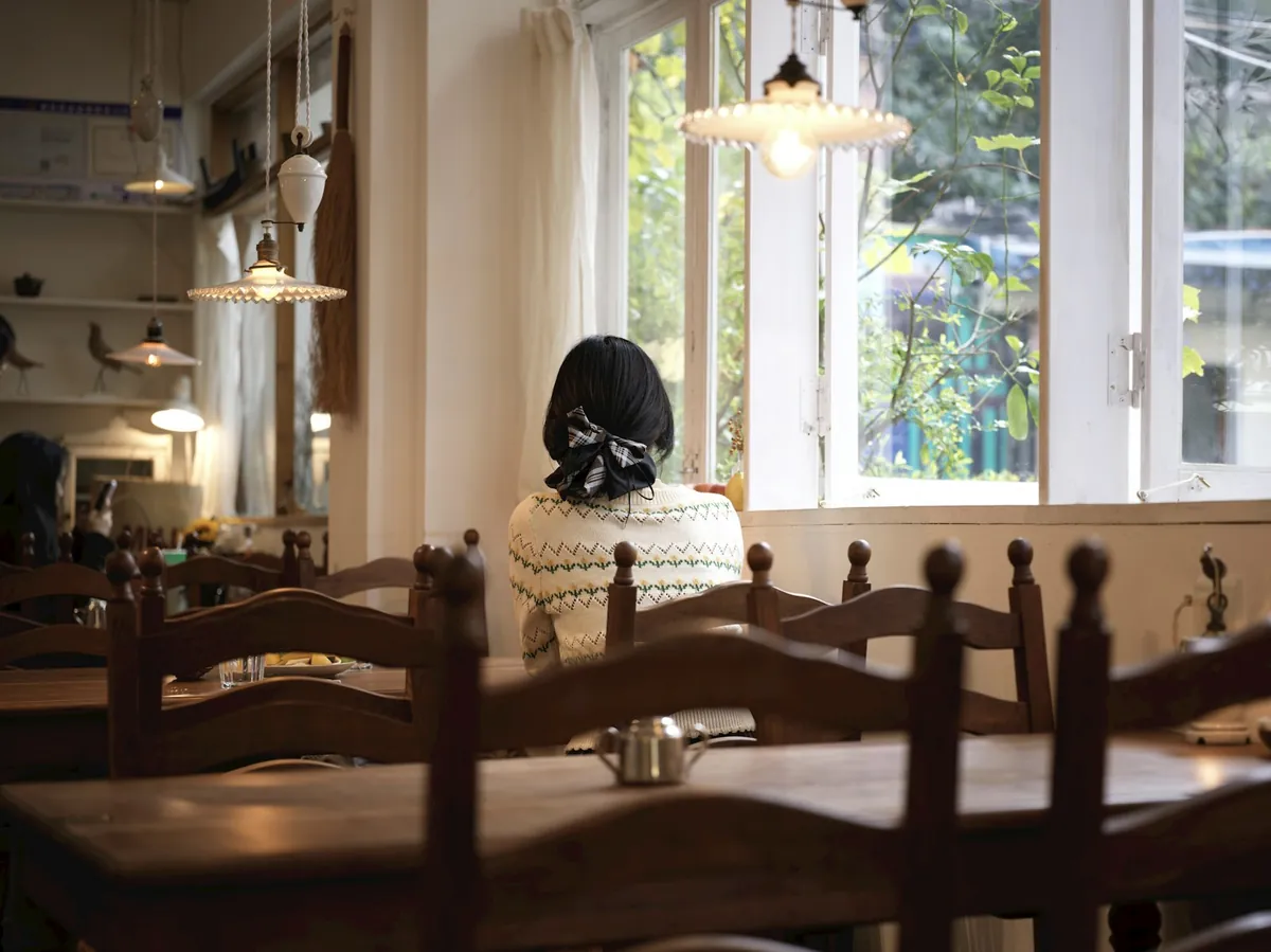 A quiet cafe interior with wooden chairs by a window