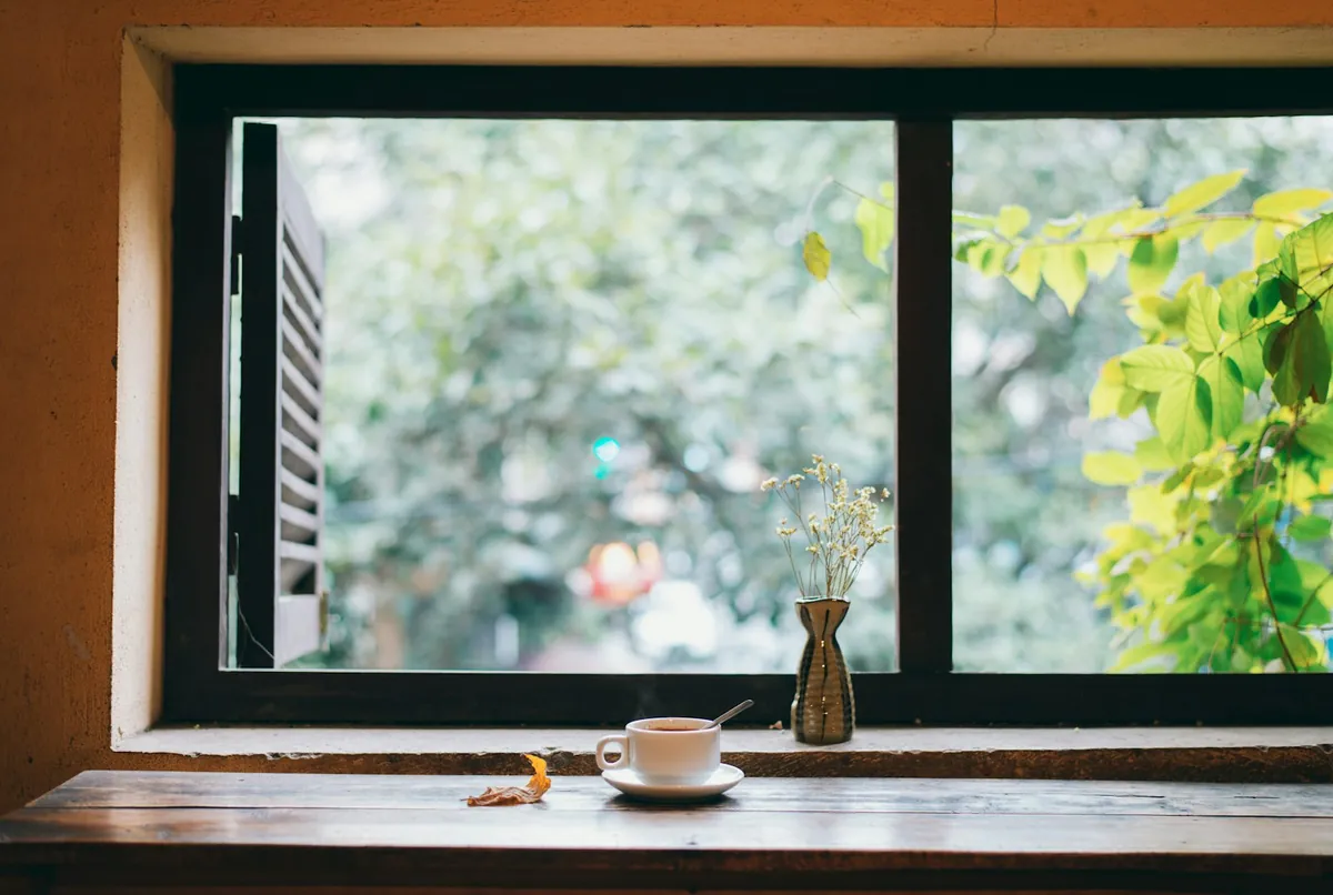 A quiet morning scene with a coffee cup by an open window