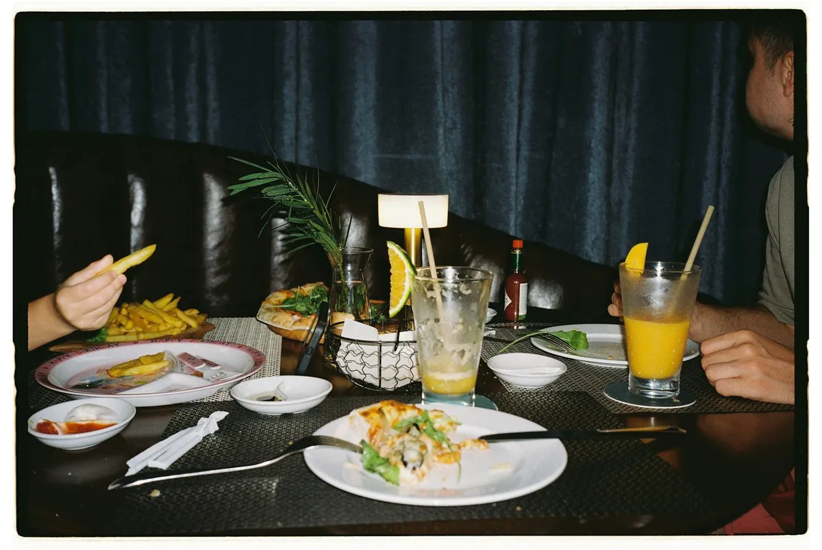 A restaurant table laid with plates of food and drinks