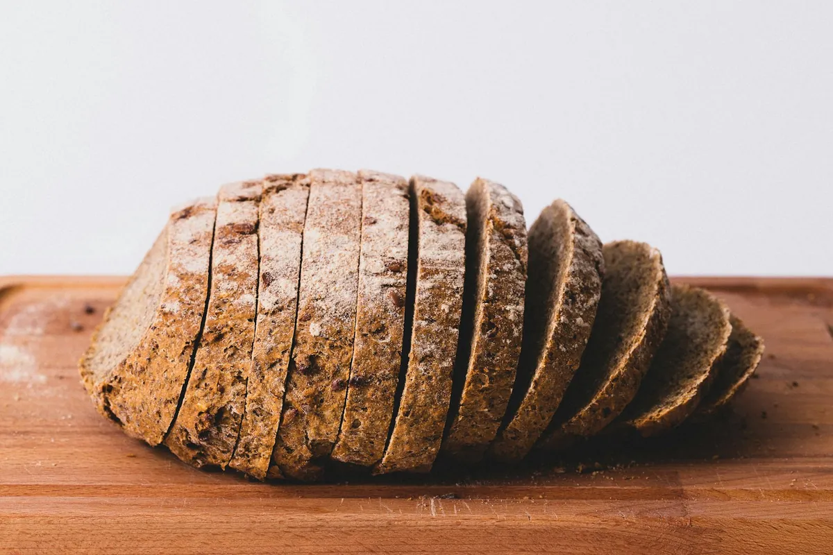 A sliced seeded loaf on a wooden board
