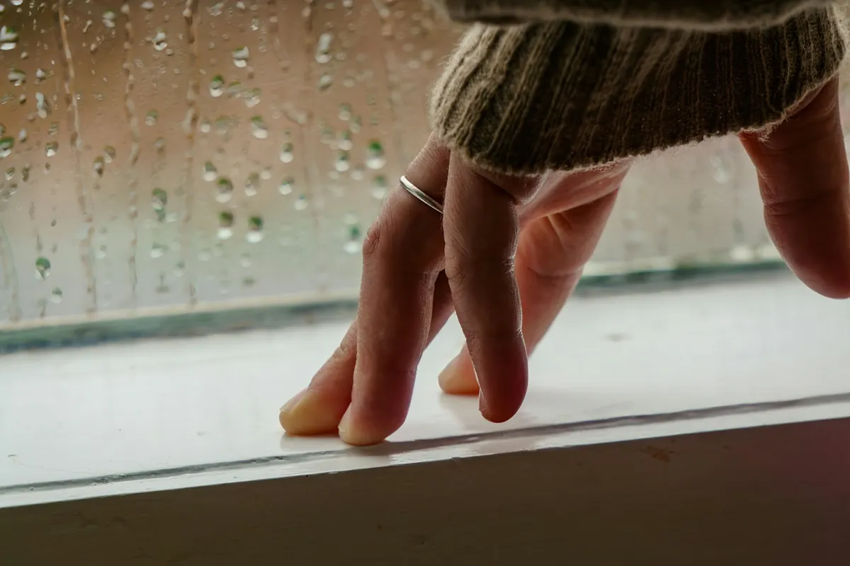 A small hand resting on a window ledge in the light