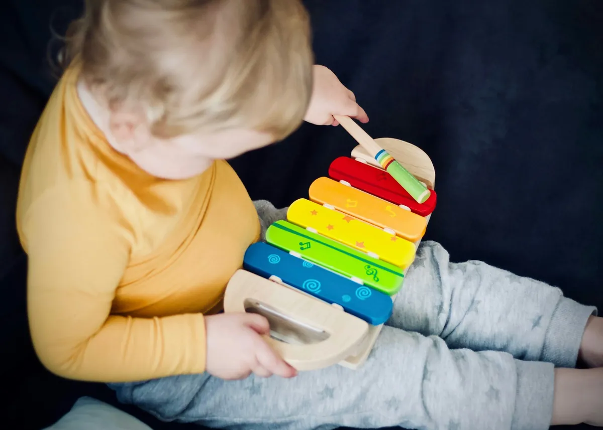 A toddler playing with a wooden toy at home
