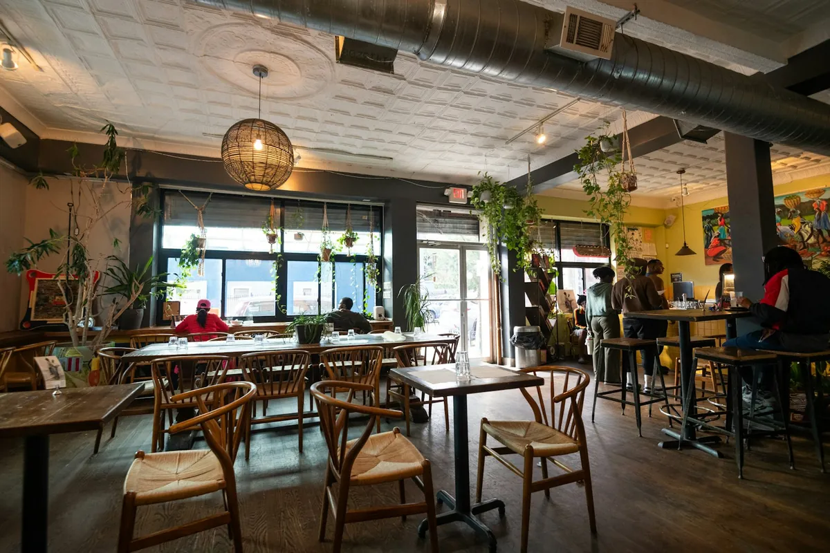A warm cafe interior with large windows and wooden seating