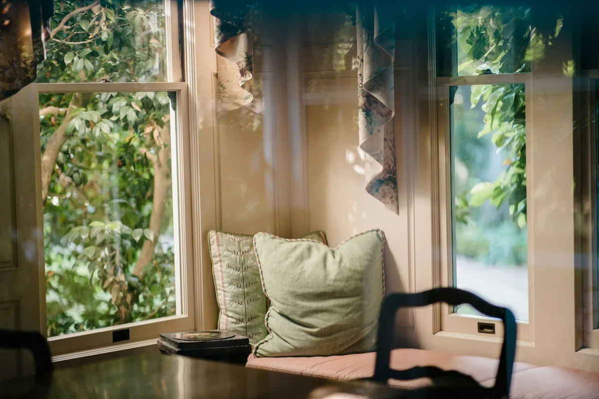 A window seat with a cushion and a view of trees