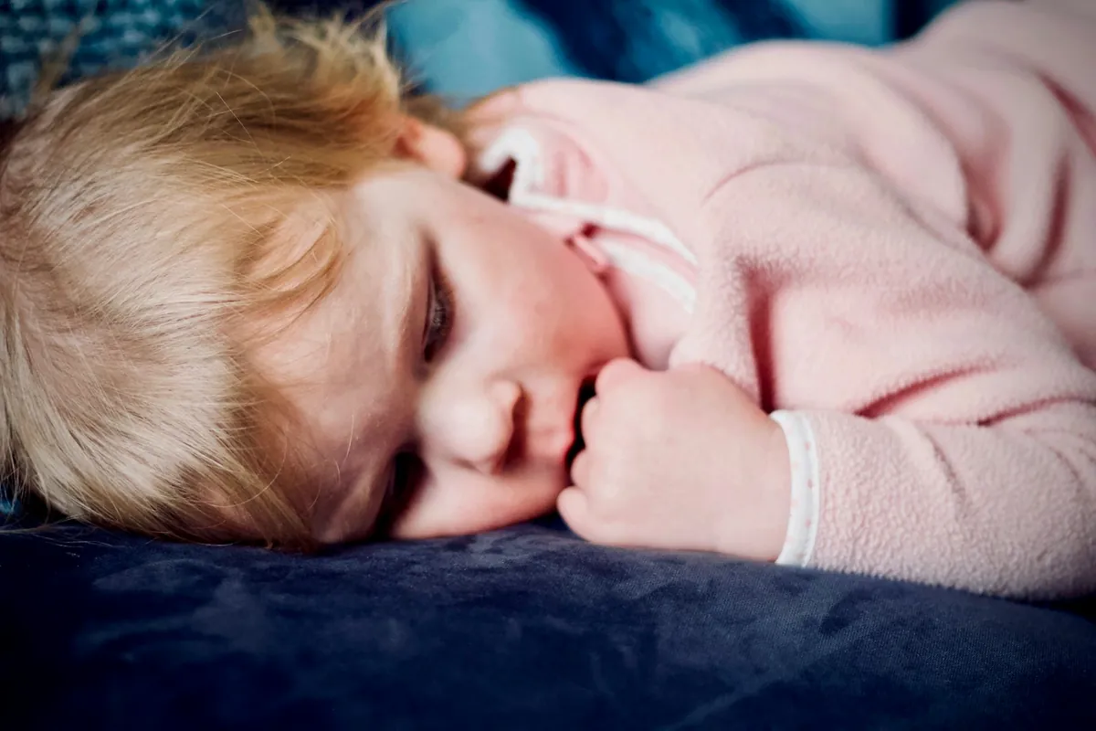 A young child asleep under a soft blanket