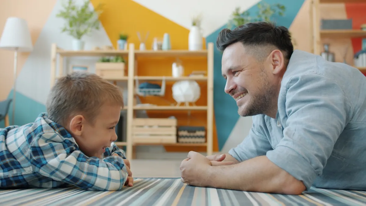 An adult lying on the floor playing with a baby in a playroom