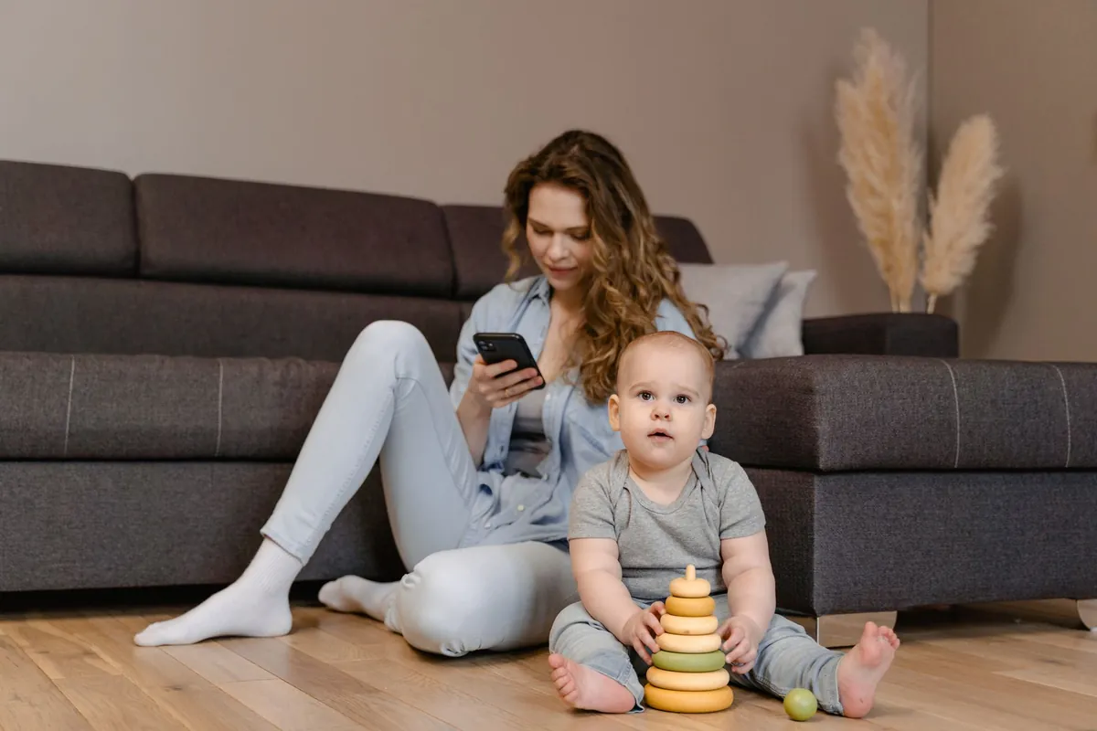 An adult and a baby sitting together on the floor