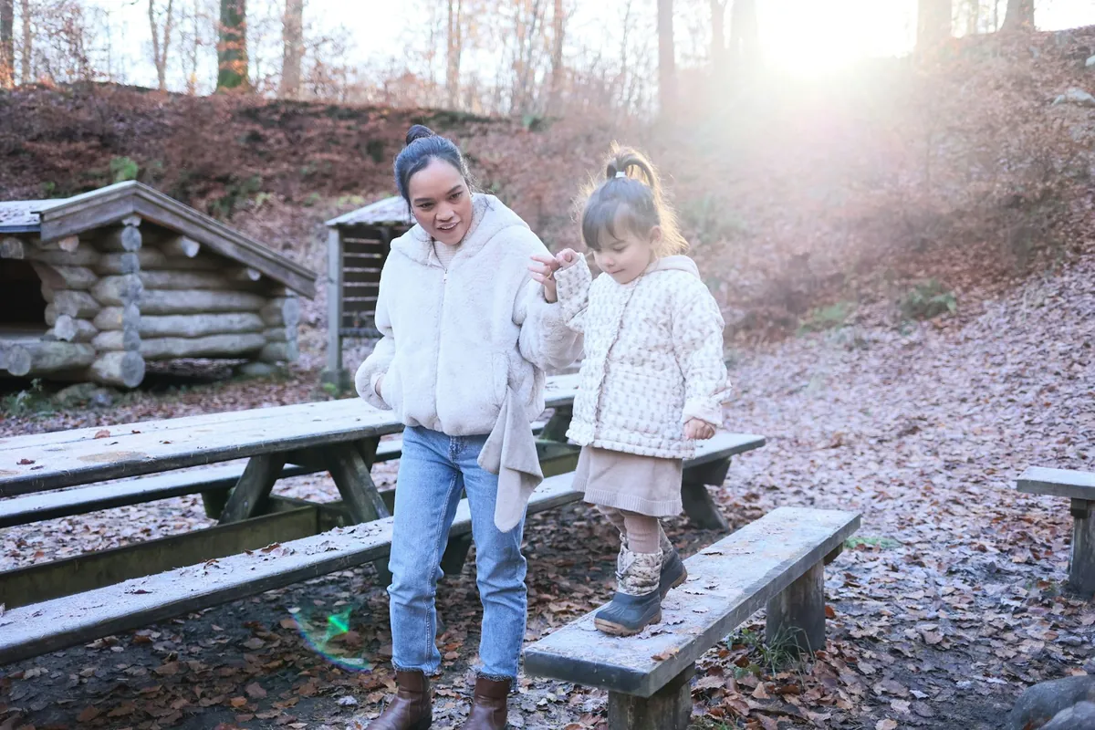 An adult and a young child walking together outdoors