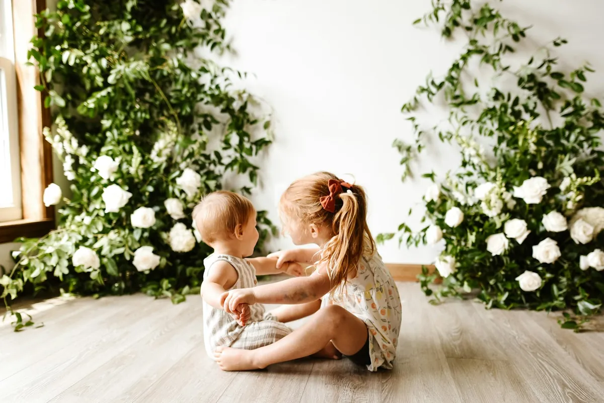 An adult sitting on the floor with two young children