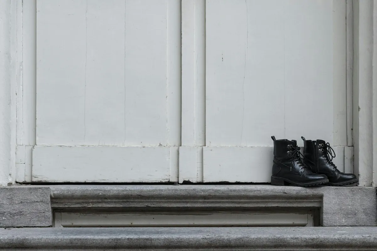 A pair of boots left on a white doorstep