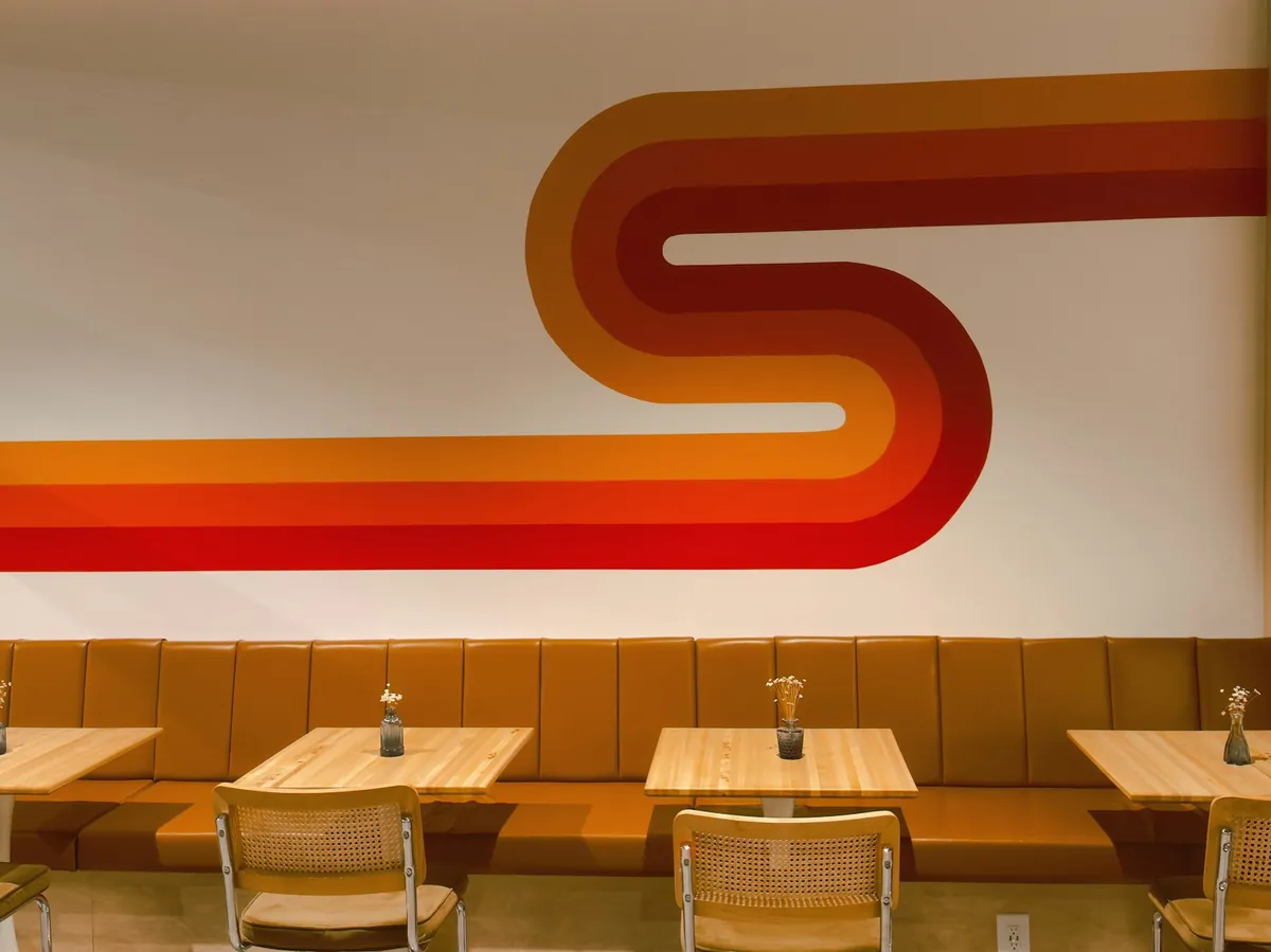Cafe tables set against a long banquette seat