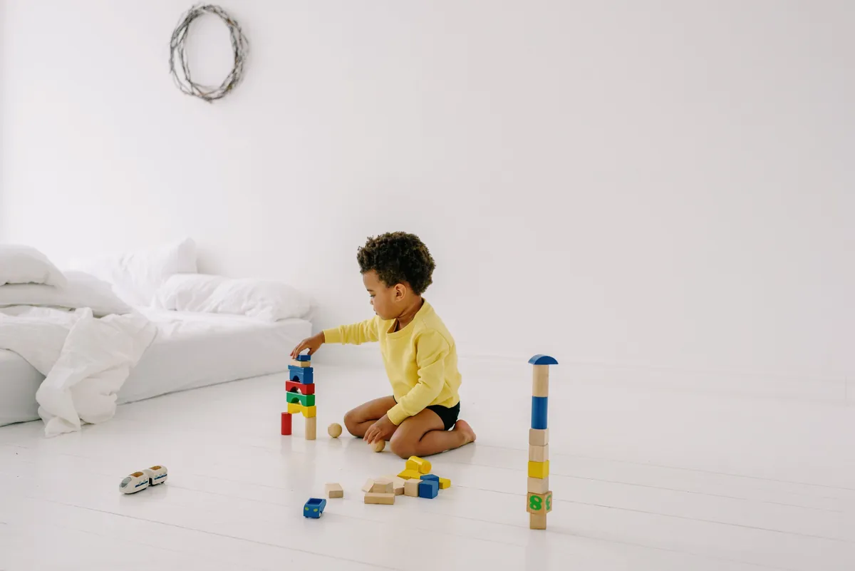 A child playing with building blocks in a large open room