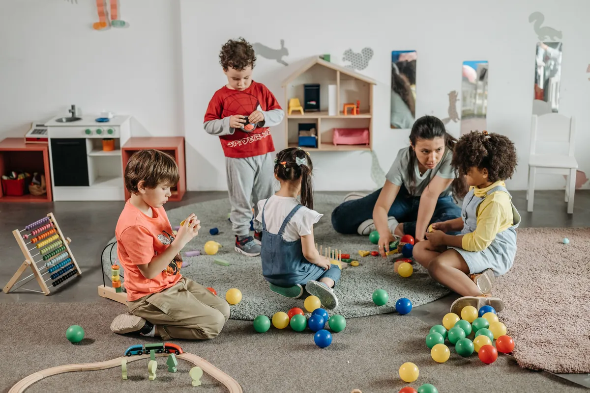 Several young children playing with toys in a bright indoor playroom