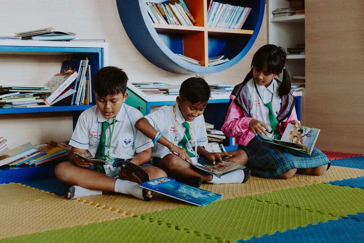 Children sitting on the floor reading books together