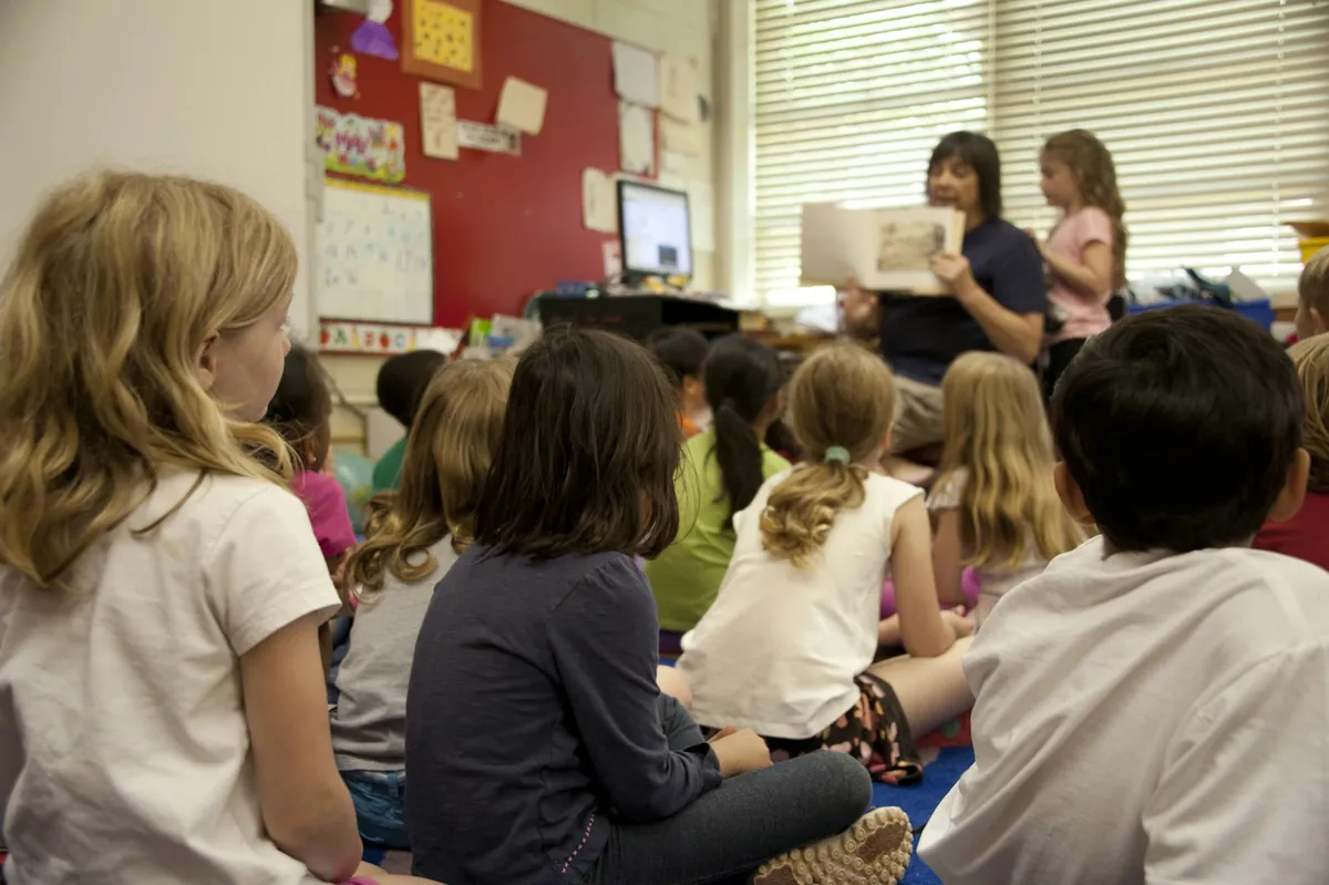 Children seated together on the floor of a classroom