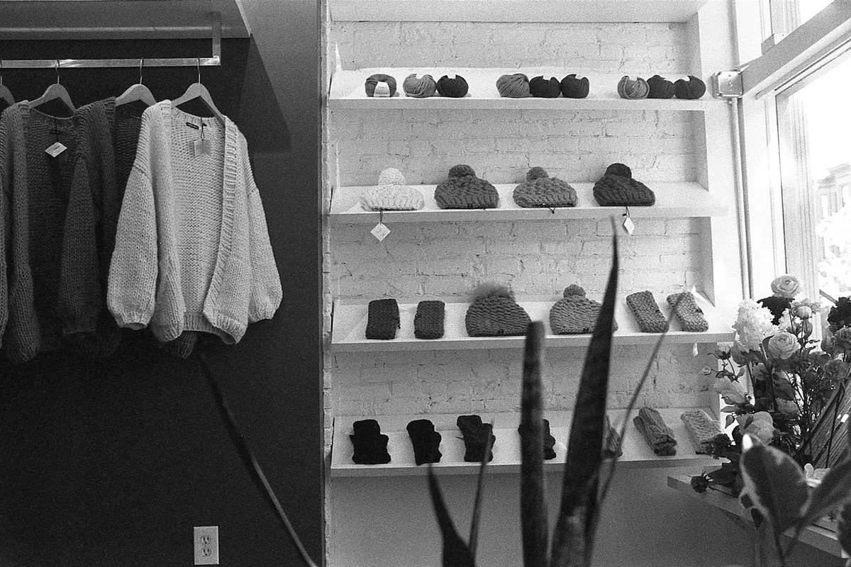 Coats hanging on a rail above a shoe rack