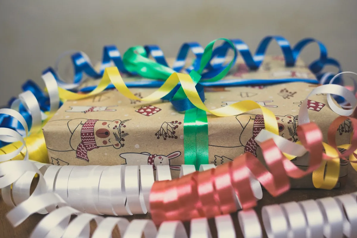 Coloured curling ribbons across a wrapped gift