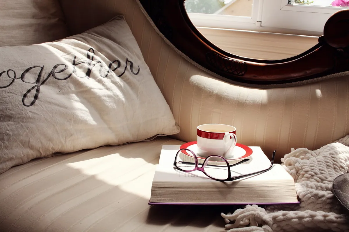 Cushions and a book resting in soft daylight