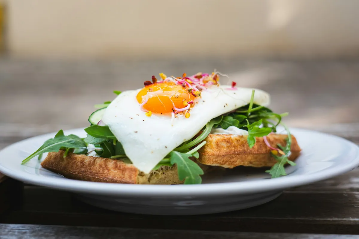 A poached egg and greens served on toast