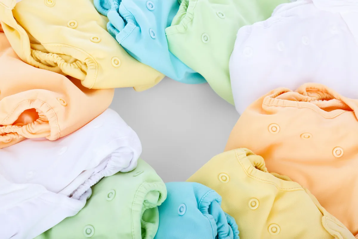 Folded baby clothes in pastel colours