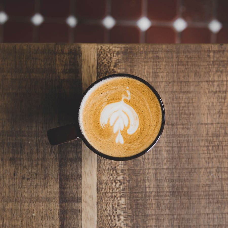A latte seen from above on a rustic wooden table
