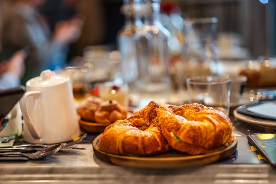 Fresh croissants and a latte on a warm wooden cafe table