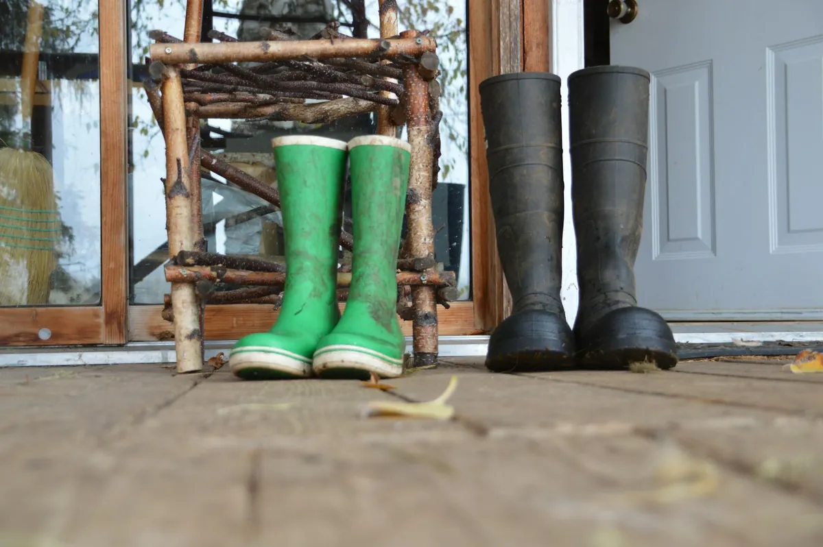Green and black wellington boots standing by a door