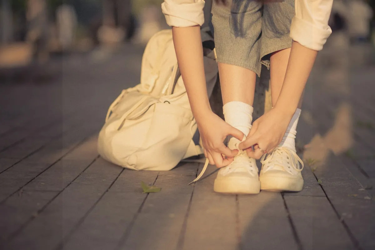 Hands fastening the strap of a small shoe